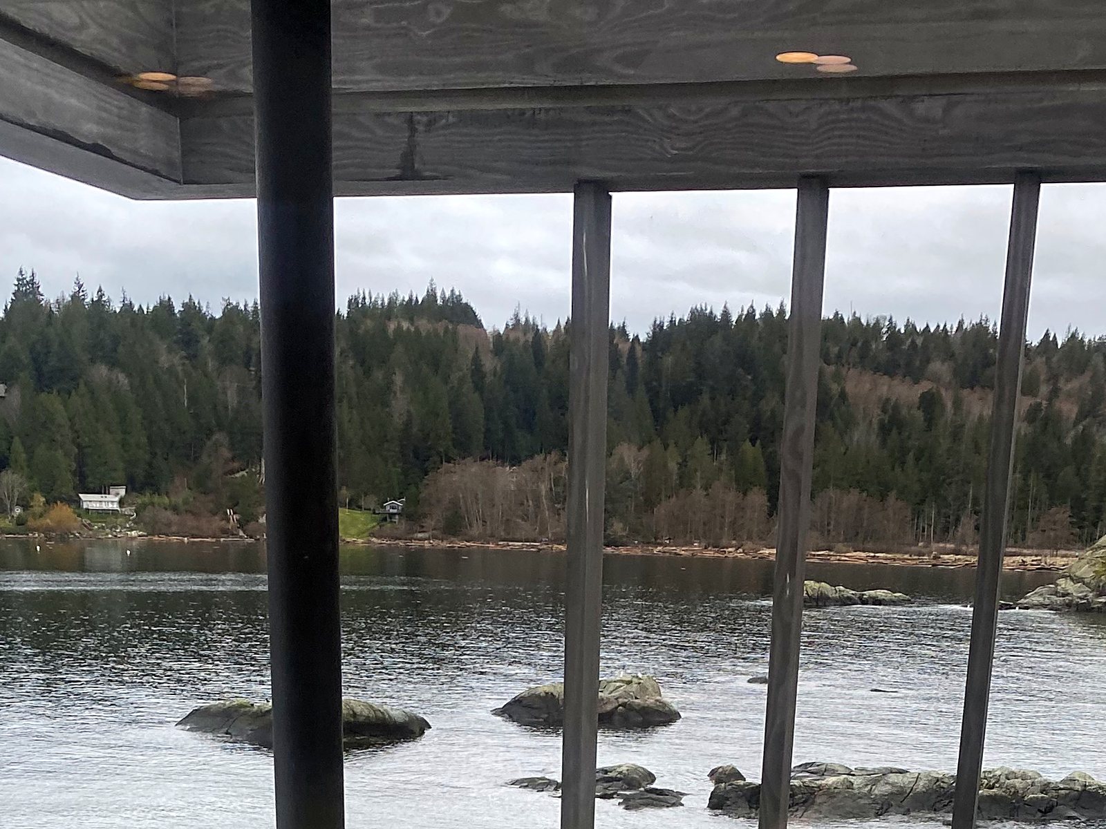 Clear view of the water through a polished glass railing on a waterfront home