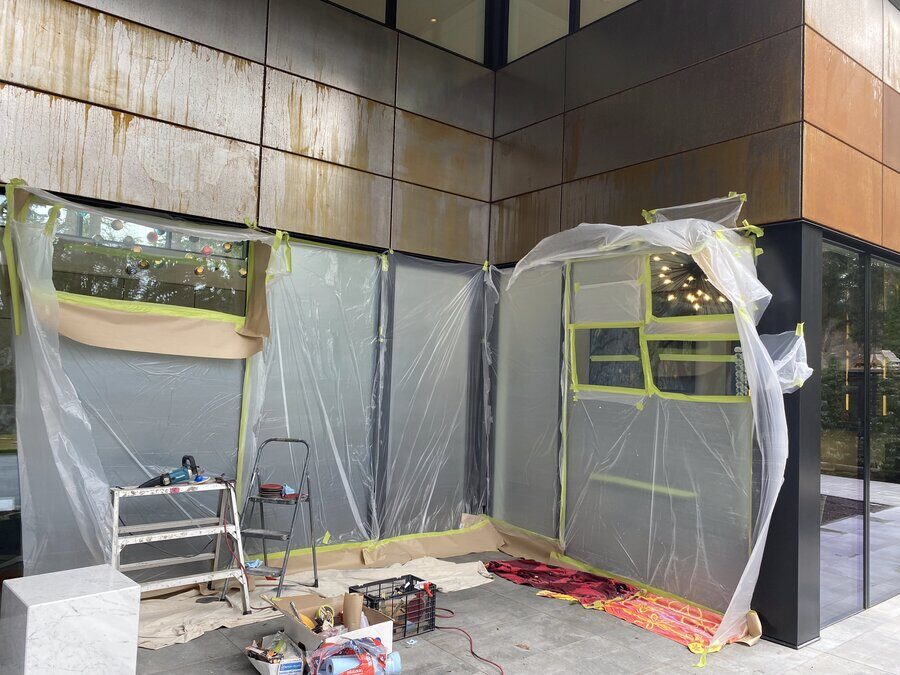 Protective sheeting and tools set up around a home's wraparound windows